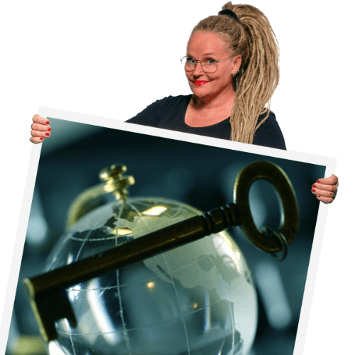 Anne Bovelett, a smiling blonde woman with a big ponytail and round glasses, holding up a polaroid with a world of glass and a key in front of that, symbolizing unlocking the world.